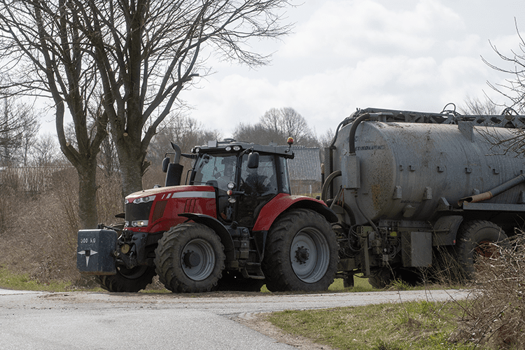 a manure truck driving down a farm road