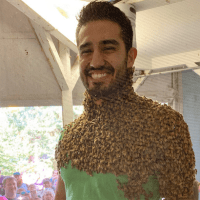 A calm demeanor is key while bees form a flowing "beard" on Joshua Muñoz