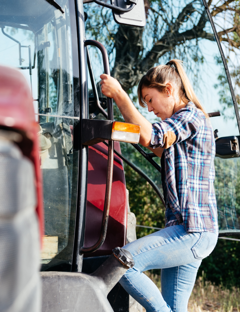 a farmer steps onto a tractor