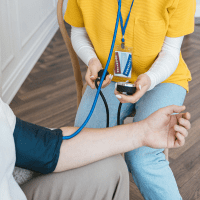 a student takes the blood pressure of a patient