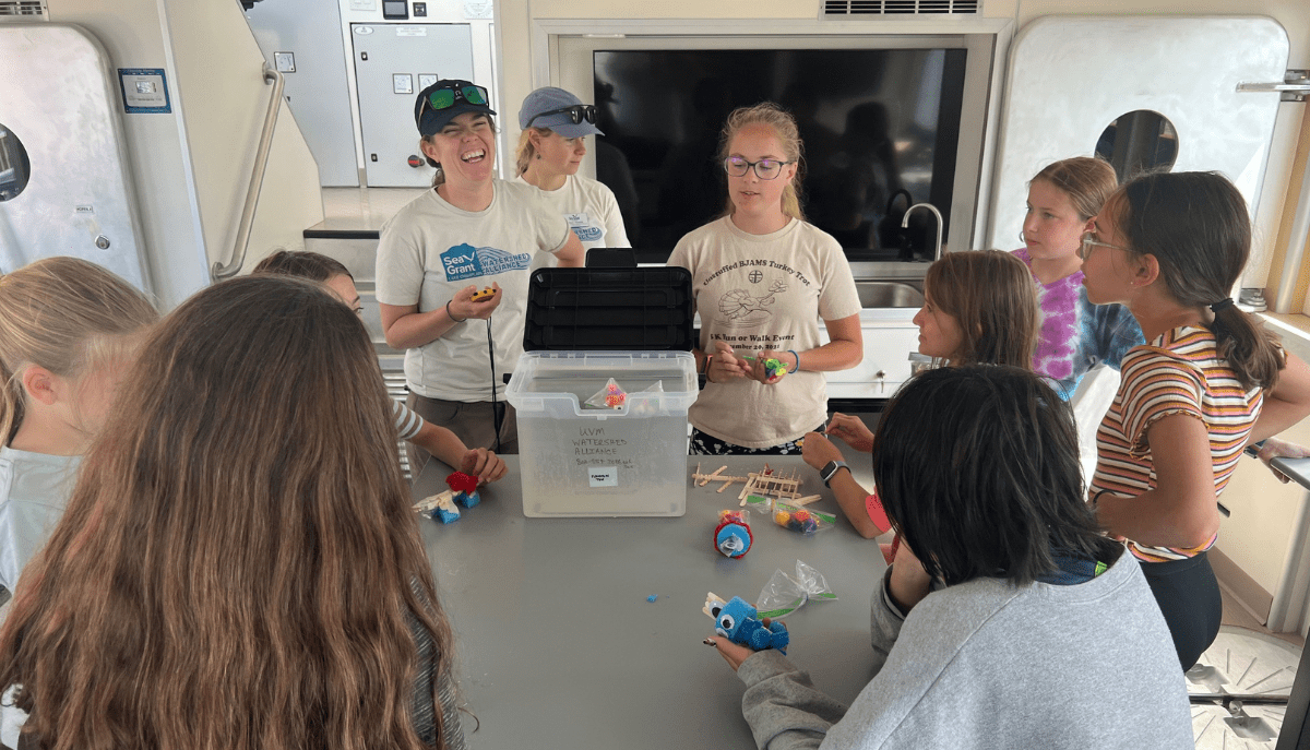 a group of students an instructor work on a project together