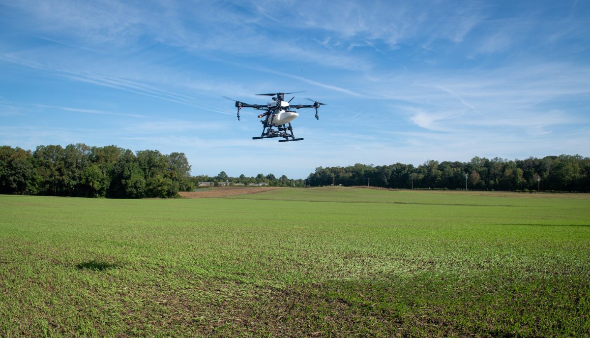 A drone flies over a field.