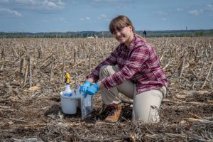 a soil scientist taking a sample in a field